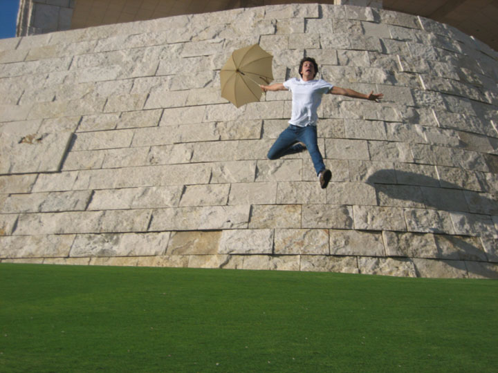 Ryan Ford with an umbrella seeming to fly off a wall at The Getty Center in Westwood