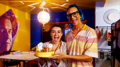 Marta Troya & Glenn Zucman smiling and holding a cake
